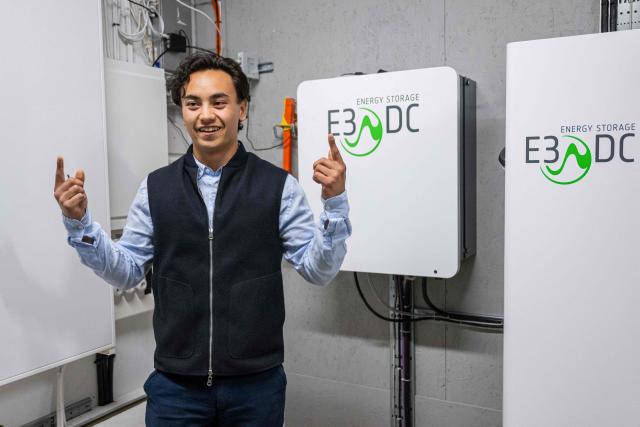 Herbert Svensson stands beside the electrical installation linking electric vehicles, stationary battery storage and the local power grid at the BRF Stenberg condominium association on May 28, 2026 in Hudiksvall, Sweden. The residential pilot project uses Vehicle-to-Grid (V2G) technology, enabling electric vehicles to act as mobile energy storage units capable of supplying electricity back to the local grid when needed. (Photo by Jonathan NACKSTRAND / AFP)