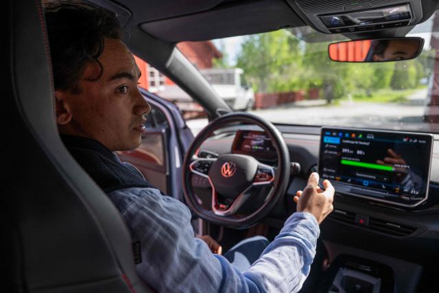 Herbert Svensson configures bi-directional charging settings inside a Volkswagen electric vehicle at the BRF Stenberg condominium association on May 28, 2026, in Hudiksvall, Sweden. The residential pilot project uses Vehicle-to-Grid (V2G) technology, enabling electric vehicles to act as mobile energy storage units capable of supplying electricity back to the local grid when needed. (Photo by Jonathan NACKSTRAND / AFP)