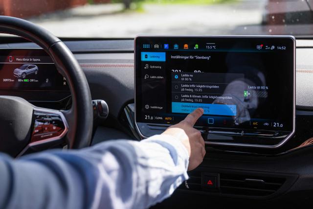 Herbert Svensson configures bi-directional charging settings inside a Volkswagen electric vehicle at the BRF Stenberg condominium association on May 28, 2026, in Hudiksvall, Sweden. The residential pilot project uses Vehicle-to-Grid (V2G) technology, enabling electric vehicles to act as mobile energy storage units capable of supplying electricity back to the local grid when needed. (Photo by Jonathan NACKSTRAND / AFP)