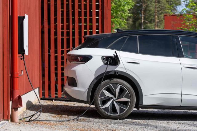 A Volkswagen electric vehicle charges at the BRF Stenberg condominium association on May 28, 2026, in Hudiksvall, Sweden. The residential pilot project uses Vehicle-to-Grid (V2G) technology, enabling electric vehicles to act as mobile energy storage units capable of supplying electricity back to the local grid when needed. (Photo by Jonathan NACKSTRAND / AFP)