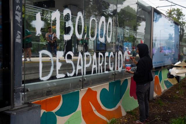 A protestor writes on a glass the number of disappeared people during a demo by the National Coordination of Education Workers (CNTE) near the Ciudad de Mexico Stadium in Mexico City on June 11, 2026, the opening day of the 2026 World Cup. (Photo by Marco González / AFP)