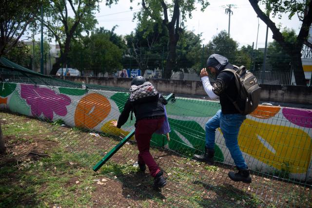 Protesters take dopwn a fence during a demo by the National Coordination of Education Workers (CNTE) near the Ciudad de Mexico Stadium in Mexico City on June 11, 2026, the opening day of the 2026 World Cup. (Photo by Marco González / AFP)