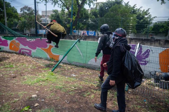 Protesters take dopwn a fence during a demo by the National Coordination of Education Workers (CNTE) near the Ciudad de Mexico Stadium in Mexico City on June 11, 2026, the opening day of the 2026 World Cup. (Photo by Marco González / AFP)