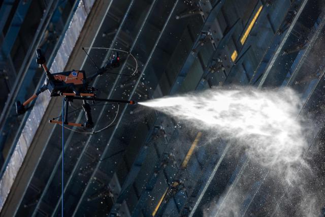 View of a drone cleaning a large building facade in Santiago, on June 11, 2026. A group of Chilean entrepreneurs created a company that uses drones to clean buildings, high-voltage towers, solar panels, and large elevated surfaces (Photo by Raul BRAVO / AFP)