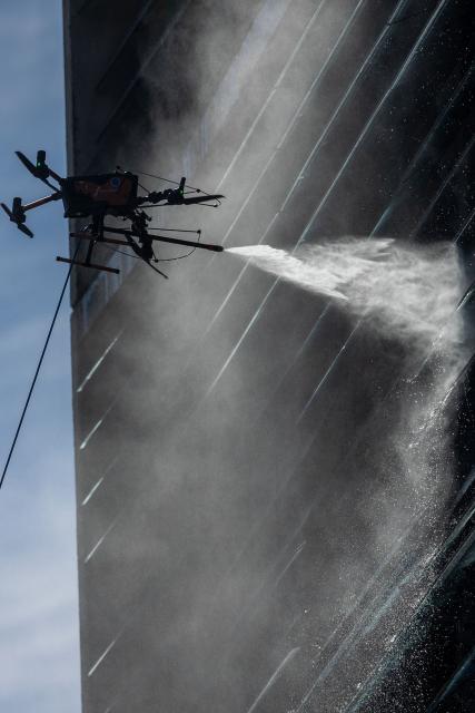 View of a drone cleaning a large building facade in Santiago, on June 11, 2026. A group of Chilean entrepreneurs created a company that uses drones to clean buildings, high-voltage towers, solar panels, and large elevated surfaces (Photo by Raul BRAVO / AFP)