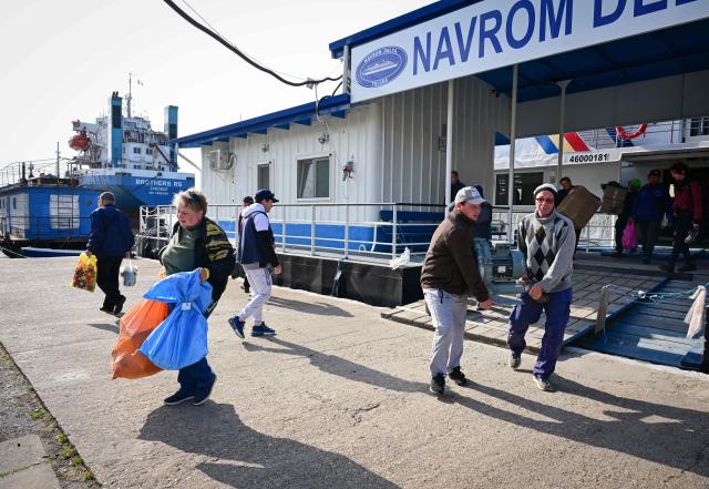 Passengers disembark from the ship coming from Tulcea in Sulina city, Romaia, on May 08, 2026. Many Romanians living near the border feel unprotected as dozens of airspace breaches were confirmed. They receive phone alerts about possible drone danger, usually during the night. In four years of war, as Russia bombed Ukrainian ports, Romanians living near the border got used to the sound of drones approaching, sometimes even crashing on national soil. NATO and the European Union are working on a possible "drone wall", with Romania, which shares a 650-km border with Ukraine, asking for capabilities from the middle of the continent to be moved on the eastern flank. (Photo by Daniel MIHAILESCU / AFP)