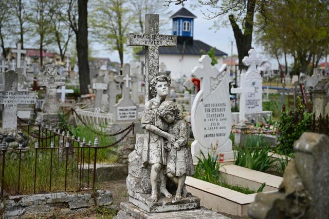 This picture shows a funeral monument belonging to Anna and Gerasimos Igglesi, two children drowned in Sulina at the beginning of 20-th century in Sulina city, Romania, on May 09, 2026. Many Romanians living near the border feel unprotected as dozens of airspace breaches were confirmed. They receive phone alerts about possible drone danger, usually during the night. In four years of war, as Russia bombed Ukrainian ports, Romanians living near the border got used to the sound of drones approaching, sometimes even crashing on national soil. NATO and the European Union are working on a possible "drone wall", with Romania, which shares a 650-km border with Ukraine, asking for capabilities from the middle of the continent to be moved on the eastern flank. (Photo by Daniel MIHAILESCU / AFP)