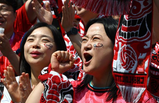 South Korean fans cheer as they watch the 2026 World Cup football match between South Korea and the Czech Republic on big screens in Seoul on June 12, 2026. (Photo by Jung Yeon-je / AFP)
