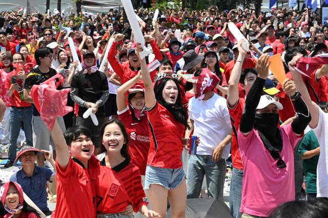 South Korean fans cheer after their team scored a goal as they watch the 2026 World Cup football match between South Korea and the Czech Republic on big screens in Seoul on June 12, 2026. (Photo by Jung Yeon-je / AFP)