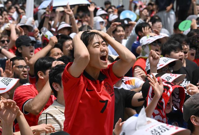South Korean fans react as they watch the 2026 World Cup football match between South Korea and the Czech Republic on big screens in Seoul on June 12, 2026. (Photo by Jung Yeon-je / AFP)