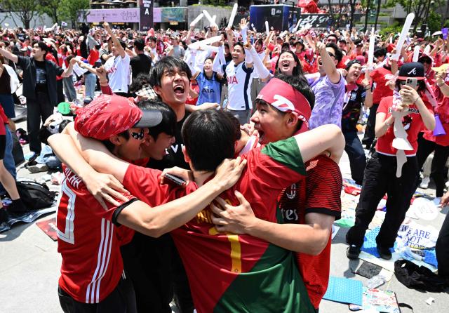South Korean fans cheer after their team scored a goal as they watch the 2026 World Cup football match between South Korea and the Czech Republic on big screens in Seoul on June 12, 2026. (Photo by Jung Yeon-je / AFP)