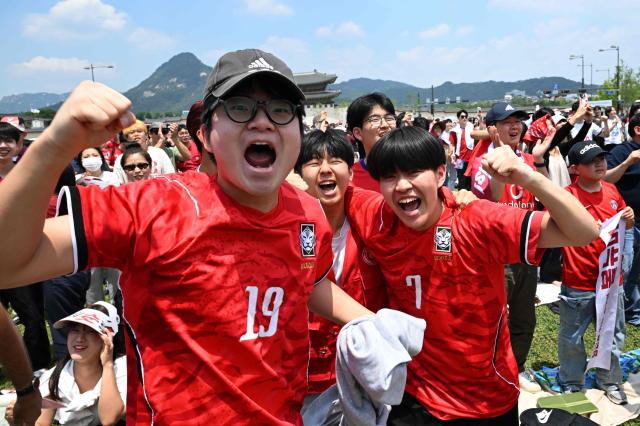 South Korean fans cheer after their team scored a goal as they watch the 2026 World Cup football match between South Korea and the Czech Republic on big screens in Seoul on June 12, 2026. (Photo by Jung Yeon-je / AFP)