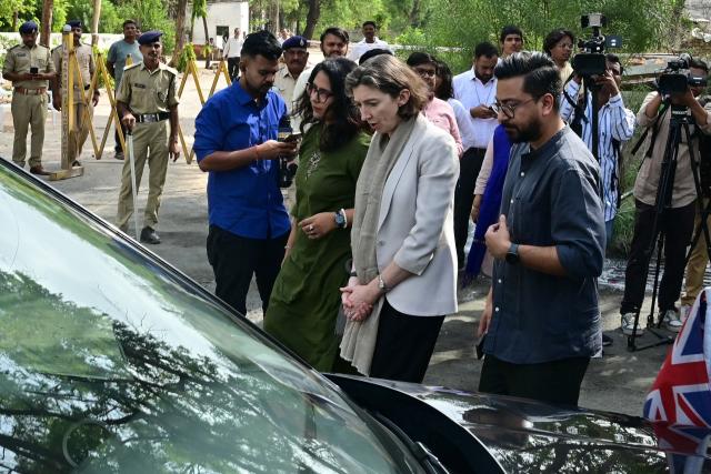 Lindy Cameron, British High Commissioner to India (C) pays tribute at Air India Flight 171 plane crash site on its first anniversary in Ahmedabad on June 12, 2026. India's aviation accident probe agency is facing renewed criticism from pilot groups on the first anniversary of the 2025 Air India Boeing-787 crash in Ahmedabad, which killed 260 people. (Photo by Shammi MEHRA / AFP)