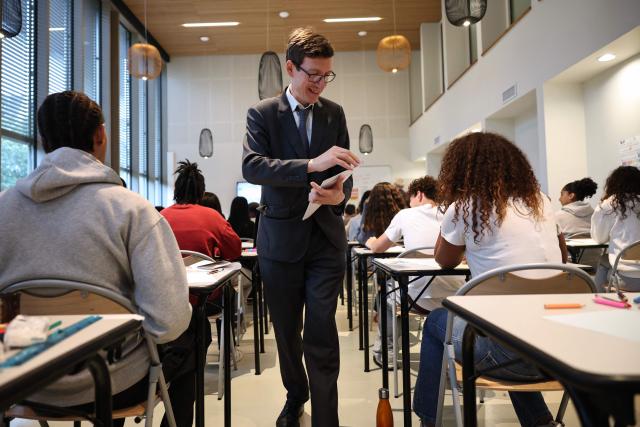 France's Education Minister Edouard Geffray (C) delivers to students their mathematics exam paper as part of the baccalaureate exam during his visit at the Gabriel Faure school and middle school in Paris on June 12, 2026. (Photo by SIMON WOHLFAHRT / POOL / AFP)