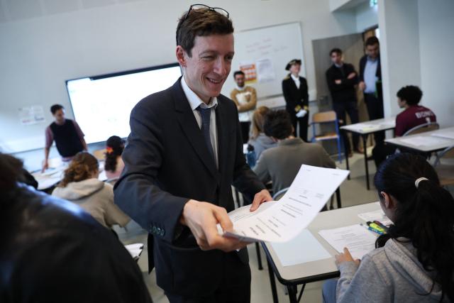 France's Education Minister Edouard Geffray delivers to students their mathematics exam paper as part of the baccalaureate exam during his visit at the Gabriel Faure school and middle school in Paris on June 12, 2026. (Photo by SIMON WOHLFAHRT / POOL / AFP)