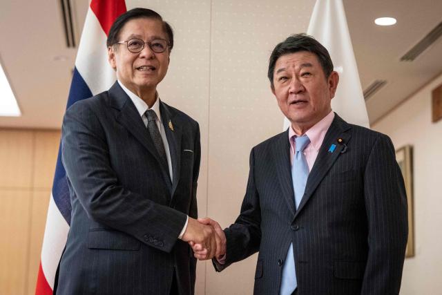 Japan's Foreign Minister Toshimitsu Motegi (R) and Thailand's Deputy Prime Minister and Foreign Minister Sihasak Phuangketkeow shake hands prior to their meeting at the Ministry of Foreign Affairs in Tokyo on June 12, 2026. (Photo by Yuichi YAMAZAKI / AFP)