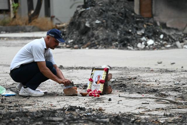 A tribute is set up for Air India Flight 171 plane crash victim  Vijay Rupani, former Gujarat chief minister, at the crash site on the first anniversary of the disaster in Ahmedabad on June 12, 2026. India's aviation accident probe agency is facing renewed criticism from pilot groups ahead of the anniversary of the 2025 Air India Boeing-787 crash in Ahmedabad, which killed 260 people. (Photo by Shammi MEHRA / AFP)