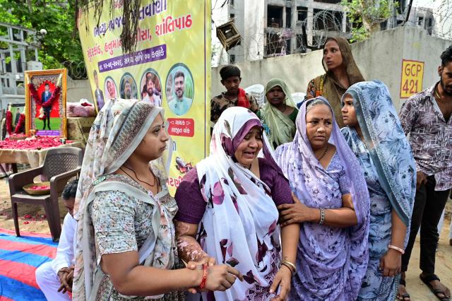 The mother (C) of Air India Flight 171 plane crash victim Akash Patni grieves at the crash site on the first anniversary of the disaster in Ahmedabad on June 12, 2026. India's aviation accident probe agency is facing renewed criticism from pilot groups ahead of the anniversary of the 2025 Air India Boeing-787 crash in Ahmedabad, which killed 260 people. (Photo by Shammi MEHRA / AFP)