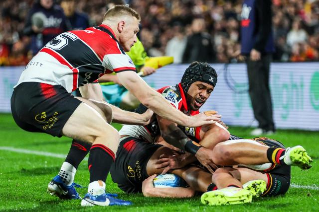 Chiefs' Kyren Taumoefolau is tackled by Crusaders' Chay Fihaki (C) during the Super Rugby semi-final match between the Waikato Chiefs and Canterbury Crusaders at FMG Stadium in Hamilton on June 12, 2026. (Photo by DJ MILLS / AFP)
