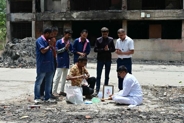 Mourners pay tribute to Air India Flight 171 plane crash victim  Vijay Rupani, former Gujarat chief minister, at the crash site on the first anniversary of the disaster in Ahmedabad on June 12, 2026. India's aviation accident probe agency is facing renewed criticism from pilot groups ahead of the anniversary of the 2025 Air India Boeing-787 crash in Ahmedabad, which killed 260 people. (Photo by Shammi MEHRA / AFP)
