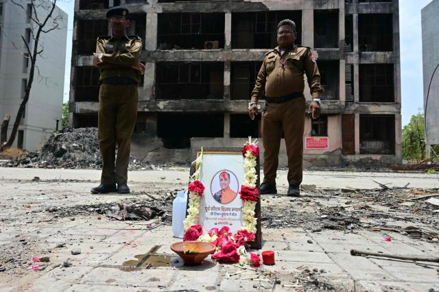 A tribute is set up for Air India Flight 171 plane crash victim  Vijay Rupani, former Gujarat chief minister, at the crash site on the first anniversary of the disaster in Ahmedabad on June 12, 2026. India's aviation accident probe agency is facing renewed criticism from pilot groups ahead of the anniversary of the 2025 Air India Boeing-787 crash in Ahmedabad, which killed 260 people. (Photo by Shammi MEHRA / AFP)