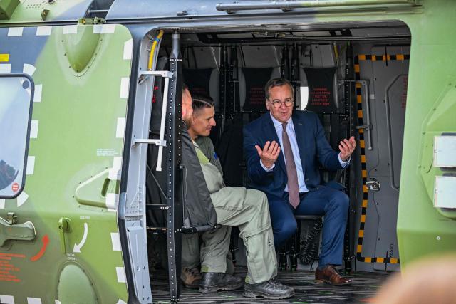 German Defence Minister Boris Pistorius talks with German soldiers as he sits in a NHIndustries NH90 twin-engine military helicopter of the German armed forces Bundeswehr as he tours the International Aerospace Exhibition (ILA) at the BER Airport in Schoenefeld, southeast of Berlin, on June 12, 2026. (Photo by RALF HIRSCHBERGER / AFP)