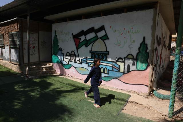 A girl walks past a mural depicting a Palestinian flag at Khan al-Ahmar in the Israeli-occupied West Bank on June 12, 2026. Excluding east Jerusalem, more than 500,000 Israelis live in settlements in the West Bank, which Israel has occupied since 1967, among some three million Palestinians. (Photo by AHMAD GHARABLI / AFP)