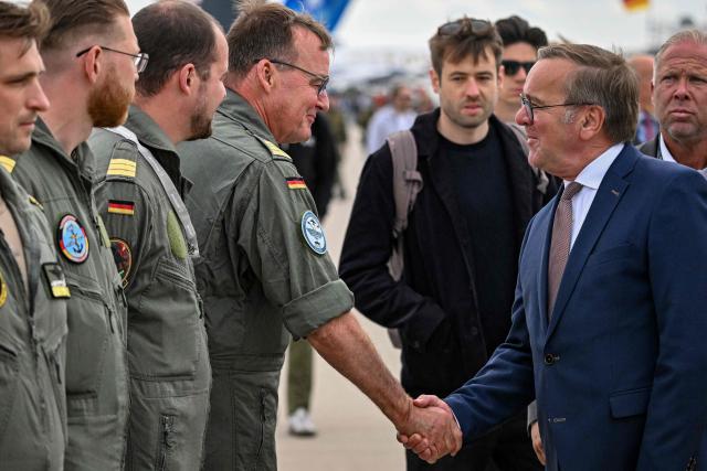 German Defence Minister Boris Pistorius greets the crew of the Boeing P-8 Poseidon aircraft as he tours the International Aerospace Exhibition (ILA) at the BER Airport in Schoenefeld, southeast of Berlin, on June 12, 2026. (Photo by RALF HIRSCHBERGER / AFP)