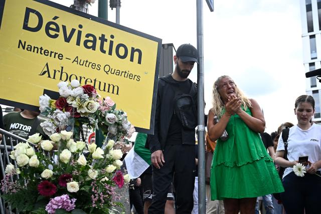 (FILES) Mounia (R), mother of Nahel, reacts after laying flowers at the location of the shooting during a gathering marking two years since the death of her son Nahel Merzouk, a 17-year-old shot dead at point-blank by police during a traffic stop, in Nanterre, west of Paris, on June 27, 2025. The Court of Cassation has overturned the reclassification of the charges against the police officer who fired the shot that killed Nahel Merzouk in June 2023, paving the way for a possible murder trial, according to the ruling seen by AFP on June 12, 2026. (Photo by JULIEN DE ROSA / AFP)