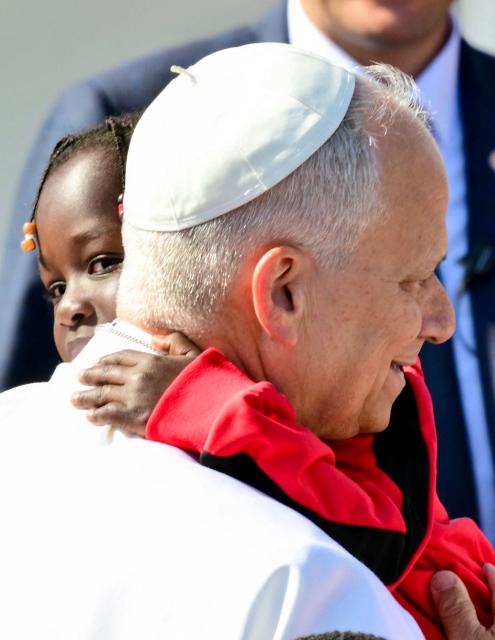 Pope Leo XIV holds a child during a meeting with migrants at the “Las Raices" (The Roots) centre in San Cristobal de la Laguna, outside Santa Cruz de Tenerife on the Canary Island of Tenerife on June 12, 2026. Pope Leo XIV is on the final day of a seven-day trip to Spain, including Barcelona and the islands of Gran Canaria and Tenerife where he will meet with migrants and organisations dedicated to helping them. (Photo by Stefano RELLANDINI / AFP)
