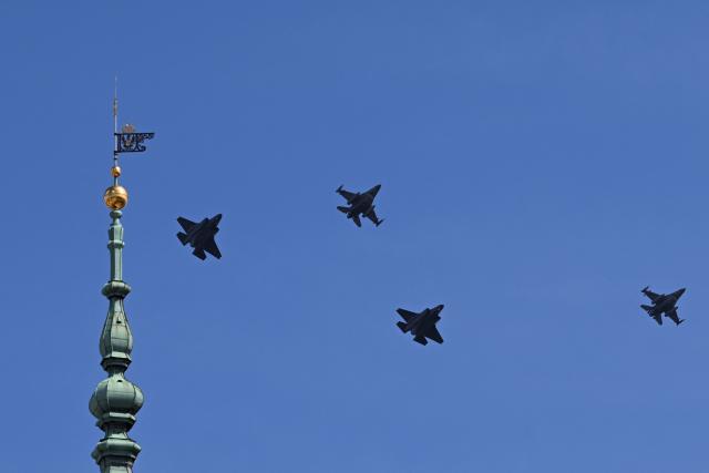 Two US-made F-35 (L and 2nd R) and two F-16 fighter jets fly past the top of the clock tower (L) of the Royal Castle in Warsaw on June 12, 2026, during a ceremonial flyover across Poland welcoming the first F-35 aircraft into service with the Polish Air Force. (Photo by Sergei GAPON / AFP)