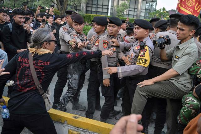 Students and police officers argue as the students were blocked while demonstrating to demand a reduction in fuel prices and the dissolution of the free meal program, which they consider to be a hotbed of corruption, in Jakarta on June 12, 2026. (Photo by BAY ISMOYO / AFP)