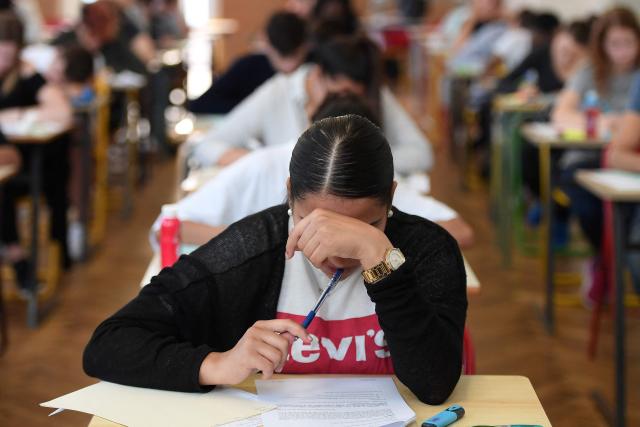(FILES) High school students work on a 4 hours philosophy dissertation, that kicks off the French general baccalaureat exam for getting into university, on June 18, 2018 at the lycee Pasteur in Strasbourg, eastern France. More than 700,000 candidates across France take the 2026 session of the Baccalaureat or "bac", the secondary school diploma required for access to higher education, with written exams running from June 15 to 18 and oral examinations through early July. (Photo by Frederick FLORIN / AFP)