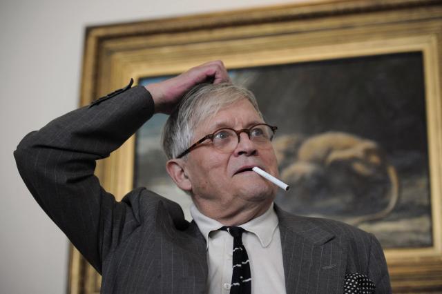 (FILES) British artist David Hockney poses for photographers with a cigarette during the press view of his forthcoming exhibition entitled 'David Hockney: A Bigger Picture' at the Royal Academy of Arts in central London, on September 7, 2011. British artist David Hockney, considered one of the most influential and defining figures in contemporary art, whose paintings captured the world in brilliant colour, has died aged 88, his public relations agent announced on June 12, 2026. (Photo by CARL COURT / AFP)