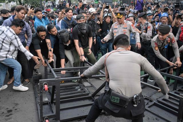 Students and police officers clash as they demonstrated to demand a reduction in fuel prices and the dissolution of the free meal program, which they consider to be a hotbed of corruption, in Jakarta on June 12, 2026. (Photo by BAY ISMOYO / AFP)