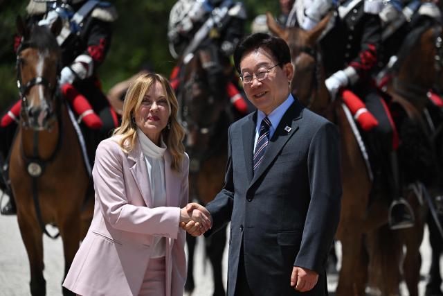 Italy's Prime Minister Giorgia Meloni (L) shakes hands as she welcomes South Korean President Lee Jae Myung before a meeting at Villa Doria Pamphili in Rome on June 12, 2026. (Photo by Andreas SOLARO / AFP)