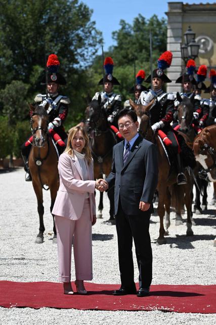 Italy's Prime Minister Giorgia Meloni (L) shakes hands as she welcomes South Korean President Lee Jae Myung before a meeting at Villa Doria Pamphili in Rome on June 12, 2026. (Photo by Andreas SOLARO / AFP)