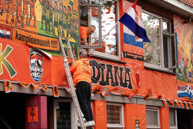 Two men work in the Marktweg street, decorated and renamed "Oranjestraat" (orange street) by its residents during the 2026 FIFA World Cup football tournament in The Hague on June 12, 2026. The Netherlands will open its 2026 FIFA World Cup Group F campaign co-hosted by the United States, Mexico and Canada, against Japan at the AT&T Stadium in Arlington on June 14, 2026. (Photo by Lina Selg / AFP)
