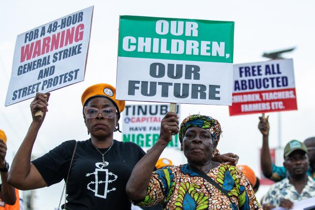 Protesters march on the street of Ojota in Lagos during the Jun 12 celebrations marking the restoration of democracy in 1999, carrying placards condemning the abduction of schoolchildren and teachers on June 12, 2026. (Photo by TOYIN ADEDOKUN / AFP)