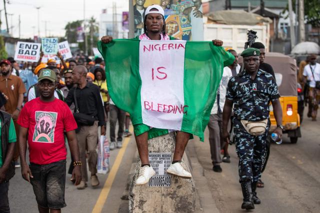 Protesters march on the street of Ojota in Lagos during the Jun 12 celebrations marking the restoration of democracy in 1999, carrying placards condemning the abduction of schoolchildren and teachers on June 12, 2026. (Photo by TOYIN ADEDOKUN / AFP)