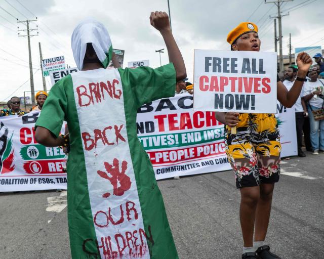 Protesters march on the street of Ojota in Lagos during the Jun 12 celebrations marking the restoration of democracy in 1999, carrying placards condemning the abduction of schoolchildren and teachers on June 12, 2026. (Photo by TOYIN ADEDOKUN / AFP)