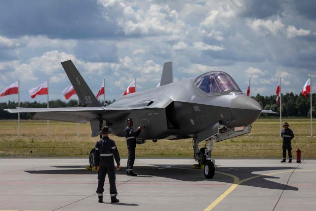 Ground crew is seen around one of the three US-made F-35 aircraft (Polish codename Husarz) in the Polish Air Force at the 32nd Tactical Air Base in Lask, central Poland, on June 12, 2026, on the day of their official entry into service with the Polish Air Force. (Photo by Wojtek RADWANSKI / AFP)
