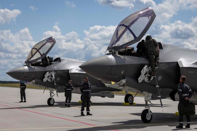 Ground crew is seen around as pilots get off two of the three US-made F-35 aircraft (Polish codename Husarz) in the Polish Air Force at the 32nd Tactical Air Base in Lask, central Poland, on June 12, 2026, on the day of their official entry into service with the Polish Air Force. (Photo by Wojtek RADWANSKI / AFP)