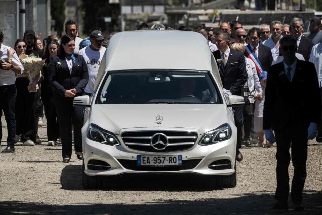 The hearse and mourners arrive at the funeral ceremony of 11-year-old girl Lyhanna in the cemetery of Fleurance, south western France on June 12, 2026. The body of Lyhanna was found last week after she went missing on May 29 in the southwestern town of Fleurance. The suspect, a 41-year-old father of a school friend of the victim, had twice before been formally accused of raping a child, but investigations had been dropped or had stalled. (Photo by Ed JONES / AFP)