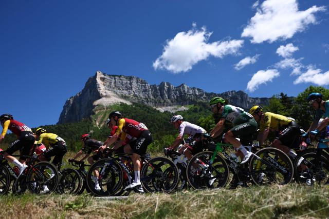 The pack of riders (peloton) cycles during the 6th stage of the Tour Auvergne-Rhone-Alpes cycling race (formerly known as the Criterium du Dauphine), 182,3km between Saint-Vulbas and Crest-Voland in the French Alps on June 12, 2026. (Photo by Anne-Christine POUJOULAT / AFP)
