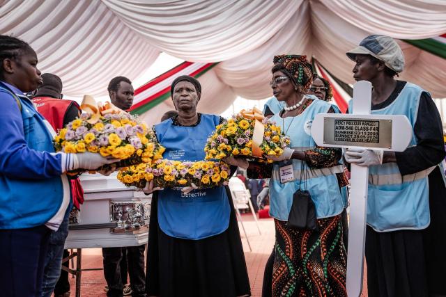 Community health volunteers carry flowers to place on the coffins of victims of the Utumishi Girls' Academy Senior School fire as mourners pray during a memorial mass amid growing concern over a wave of school fires across Kenya at Gilgil Stadium in Gilgil, on June 12, 2026. The blaze at Utumishi Girls Academy last month left 16 schoolgirls dead and 132 injured, according to the Kenya Red Cross, one of 47 fires that have broken out across the country this year.The spate of school fires has provoked a national conversation, and raised urgent political questions.But at Gilgil Stadium, in Nakuru County about 120 kilometres (75 miles) north of Nairobi, spiritual leaders steered the conversation away from political questions. (Photo by Luis TATO / AFP)