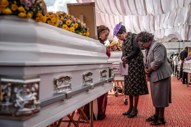 Women clergy pray in front of the coffin of a victim of the Utumishi Girls' Academy Senior School fire as they join prayers with religious leaders from several denominations during a memorial mass amid growing concern over a wave of school fires across Kenya at Gilgil Stadium in Gilgil, on June 12, 2026. The blaze at Utumishi Girls Academy last month left 16 schoolgirls dead and 132 injured, according to the Kenya Red Cross, one of 47 fires that have broken out across the country this year.The spate of school fires has provoked a national conversation, and raised urgent political questions.But at Gilgil Stadium, in Nakuru County about 120 kilometres (75 miles) north of Nairobi, spiritual leaders steered the conversation away from political questions. (Photo by Luis TATO / AFP)