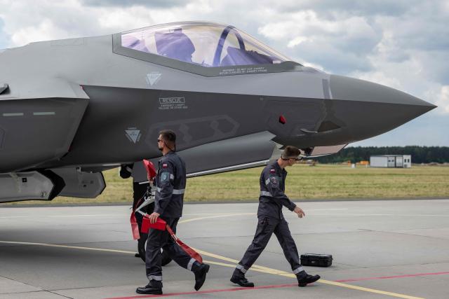 Ground crew is seen around one of the three US-made F-35 aircraft (Polish codename Husarz) in the Polish Air Force at the 32nd Tactical Air Base in Lask, central Poland, on June 12, 2026, on the day of their official entry into service with the Polish Air Force. (Photo by Wojtek RADWANSKI / AFP)