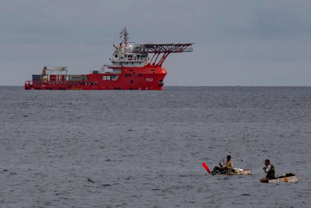 Men fish as the Colombian Navy ship ARC Caribe arrives in Cuba carrying humanitarian aid in Havana, on June 12, 2026.  (Photo by YAMIL LAGE / AFP)