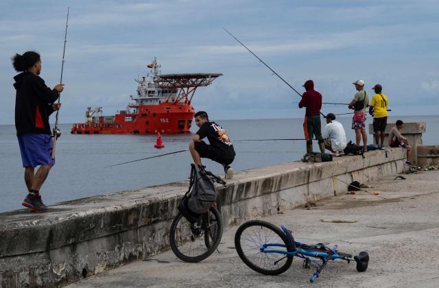 Men fish as the Colombian Navy ship ARC Caribe arrives in Cuba carrying humanitarian aid in Havana, on June 12, 2026.  (Photo by YAMIL LAGE / AFP)